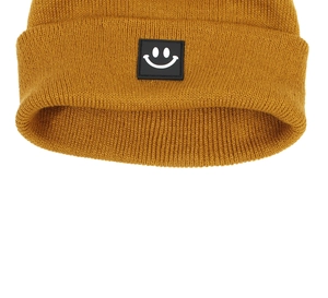 Primo piano del berretto in maglia giallo zenzero con trama spessa e toppa smiley