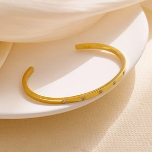 Detail of 18k gold plated stainless steel C-shape bangle with sparkling cubic zirconia