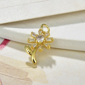 Close-up of a gold sunflower pendant featuring clear cubic zirconia and leaf details