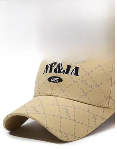 Detail of khaki baseball cap with NY&JA 1987 embroidery and diamond grid pattern