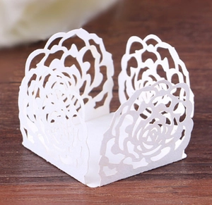 Detail of laser-cut rose lace pattern on white paper candy boxes for wedding parties