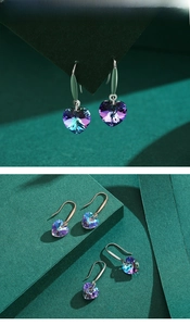 Detailed view of heart-shaped crystal earrings with silver and rose gold ear hooks