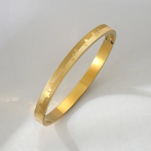 Bracciale rigido minimalista in acciaio al titanio dorato con stelle e spazzolato
