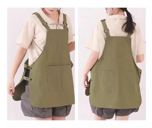 Detail view of army green apron with adjustable side snaps and large utility pocket