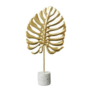 Modern gold Monstera leaf sculpture with white terrazzo base for living room decor