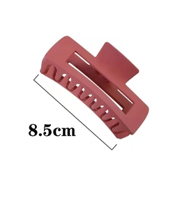 Close-up of 8.5cm matte pink hair claw clip showing textured resin material and design