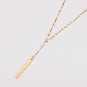 Detail shot of a minimalist gold vertical bar pendant on a polished stainless steel chain