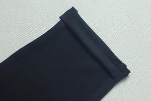 Détail de la manchette en tricot noir avec coutures renforcées sur tissu extensible