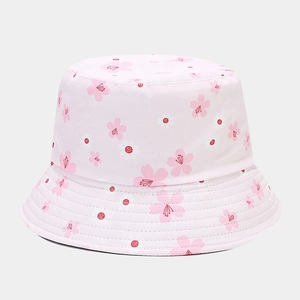 Close-up of the cherry blossom pattern on a soft pink cotton bucket hat with white flowers