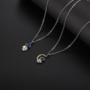 Detail of silver astronaut pendants with gold star and moon on silver chain necklace