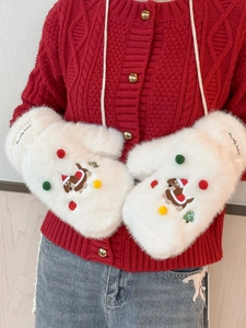 Détail de moufles blanches en peluche avec broderie de chien et pompons colorés