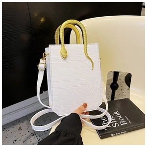 Close-up of white croc-embossed texture and golden snake-shaped handle on a tote bag