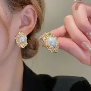 Vintage style gold hammered flower earrings with large iridescent white pearl detail