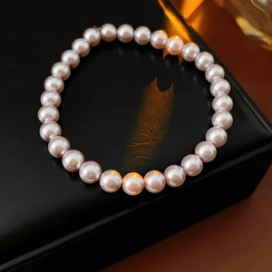Detailed view of 8mm pink pearl bracelet on premium black leather jewelry display