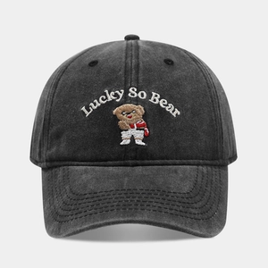 Detailed view of the Lucky So Bear white embroidery on a washed grey cotton baseball cap