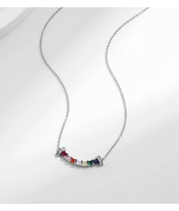 Macro shot of curved rainbow gemstone pendant on silver chain necklace