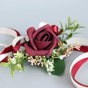 Boutonnière élégante avec rose artificielle rouge foncé et rubans pour mariage et célébration
