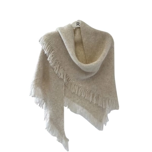 Soft beige wool blend shawl with fringe details displayed on a hanger for autumn/winter