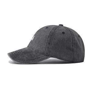 Gros plan sur le coton gris foncé délavé et la broderie blanche de la lettre A sur la casquette