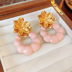 Vue détaillée des boucles d'oreilles fleur vintage avec cerceau rose sur boîte