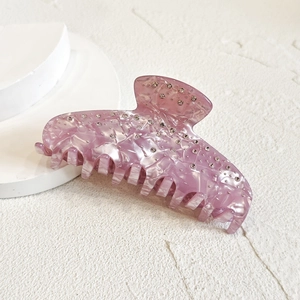 Macro detail of lavender rhinestone hair claw clip showing polished texture and sparkling crystals
