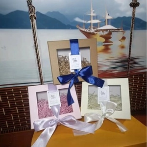 Detailed view of square window gift boxes with decorative ribbons and shredded paper fill