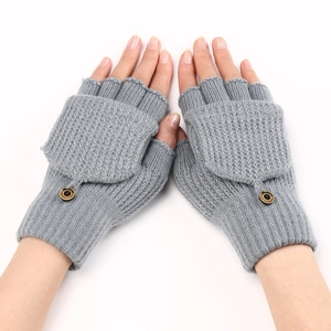 Detail of grey knitted fingerless gloves showing a buttoned flap and textured ribbed fabric