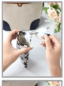 Detail showing cow print soft leather pouch with gold metal round frame glasses inside
