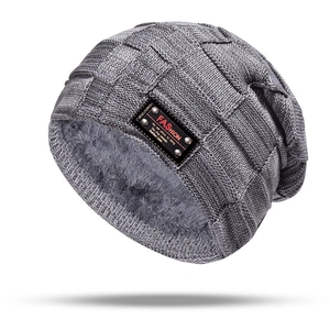 Detail of dark grey knit beanie featuring plush faux fur lining and square pattern texture