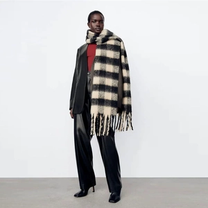 Close-up of black and white plaid cotton scarf with handmade knotted tassel fringe detail