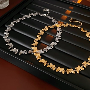 Elegant gold and silver titanium steel butterfly choker necklaces on a display tray