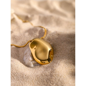 18k gold plated stainless steel necklace with irregular hammered pendant on white sand