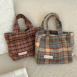 Detailed close-up of vintage plaid tote bags in red and blue check patterns with fabric label