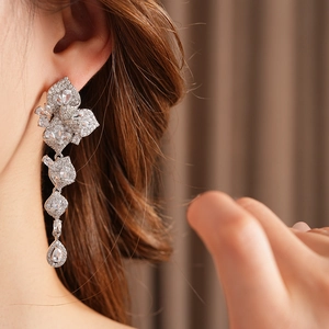 Gros plan de boucles d'oreilles pampilles fleurs en zircon avec détails feuilles