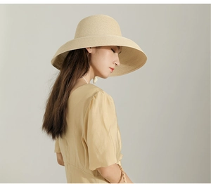 Close-up of the elegant woven texture and wide brim of a vintage beige straw sun hat