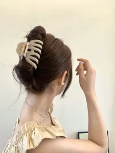 Rear view of model wearing a large cream matte pumpkin hair claw for thick hair styling