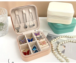 Detail view of pink, beige, and mint green portable PU leather jewelry storage boxes
