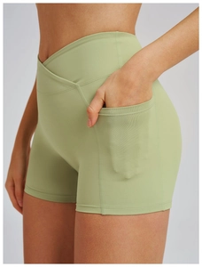 Detail of high-waisted yoga shorts with crossover waistband and side phone pocket
