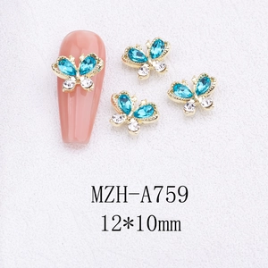 Detailed view of 3D alloy butterfly nail charms with light blue crystals and gold frame