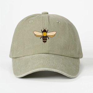 Detailed close-up of premium embroidered bee on washed cotton baseball cap fabric