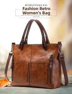 Detail of vintage brown PU leather tote bag with symmetrical zipper pockets and thick handles
