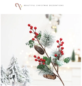 Close-up of artificial Christmas pine branch with red berries and snowy pine cones