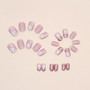 Short matte pink press-on nails with sparkling glitter, snowflakes, and festive rhinestones