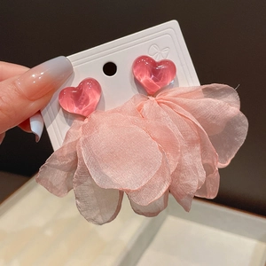 Detailed macro view of pink floral tassel earrings with heart-shaped resin studs