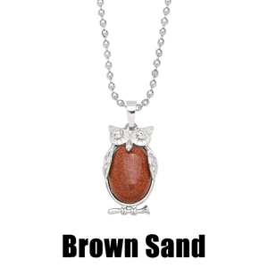 Detailed shot of retro owl pendant with brown sand gemstone and silver bead chain