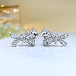 Elegant silver bow earrings with sparkling zircon crystals in a minimalist luxury style