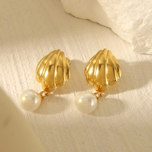 Elegant 18k gold stainless steel seashell earrings with white pearl drop on stone surface