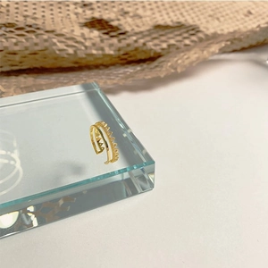 Close-up of golden crown-shaped double layer ring on geometric glass block
