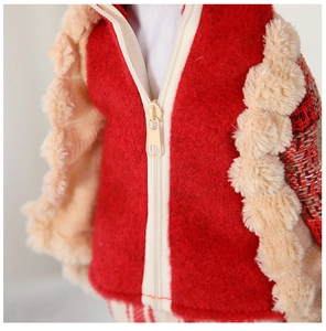 Detail of red and beige knitted reindeer doll with zipper and soft faux fur textures