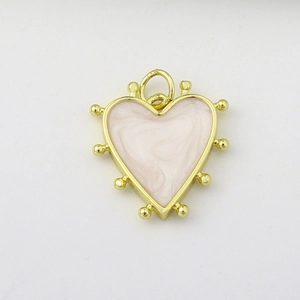 Detail view of heart-shaped gold charm with pink marble texture and micro-ball edges